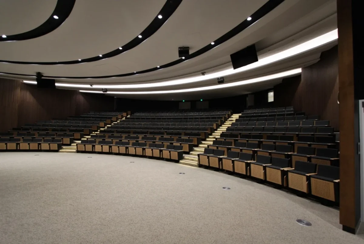 Curved commercial auditorium furniture and tiered seating fitout designed and supplied for Woodside Energy corporate auditorium in Western Australia