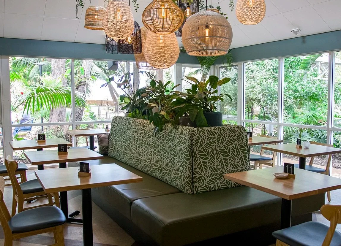 Custom upholstered booth seating by Robinson Group with tropical-inspired fabric and Tasmanian Oak tables at Tonic by the Bay, a coastal bar and restaurant in Busselton.