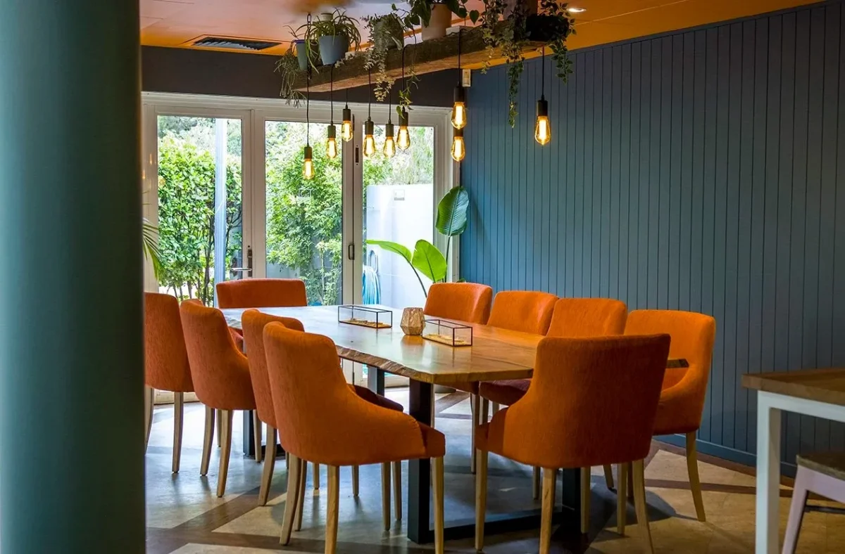 Chai Chairs custom upholstered in burnt orange fabric surrounding a Tasmanian Oak table at Tonic by the Bay, designed and supplied by Robinson Group for a relaxed coastal dining setting.