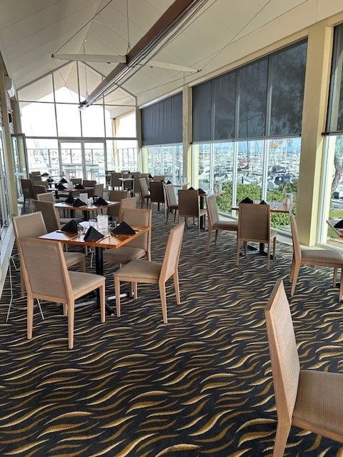 Dining area at Hillarys Yacht Club furnished with Juniper commercial dining chairs and custom solid Marri tables overlooking the marina
